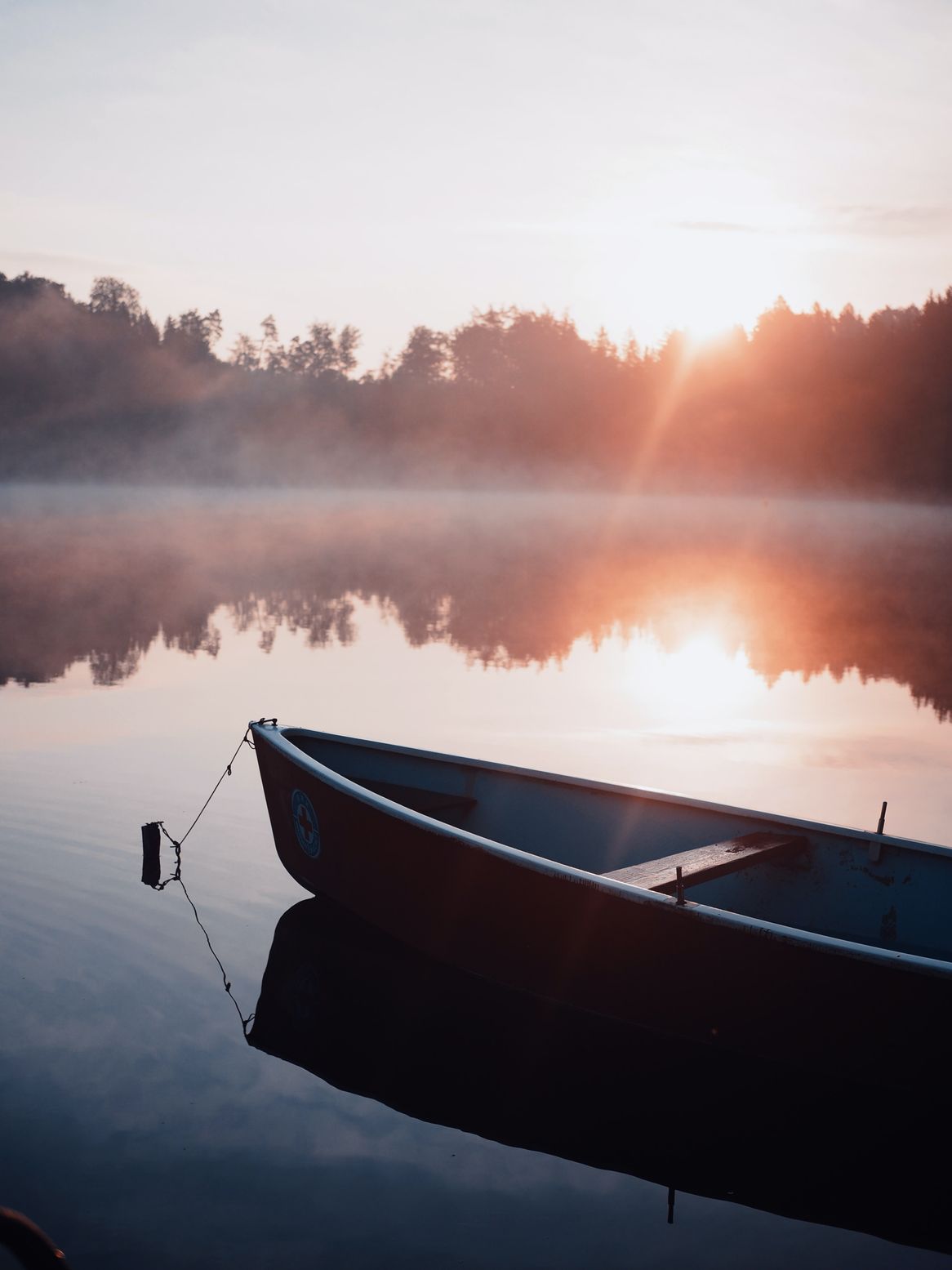 roddbåt på en sjö med solnedgång